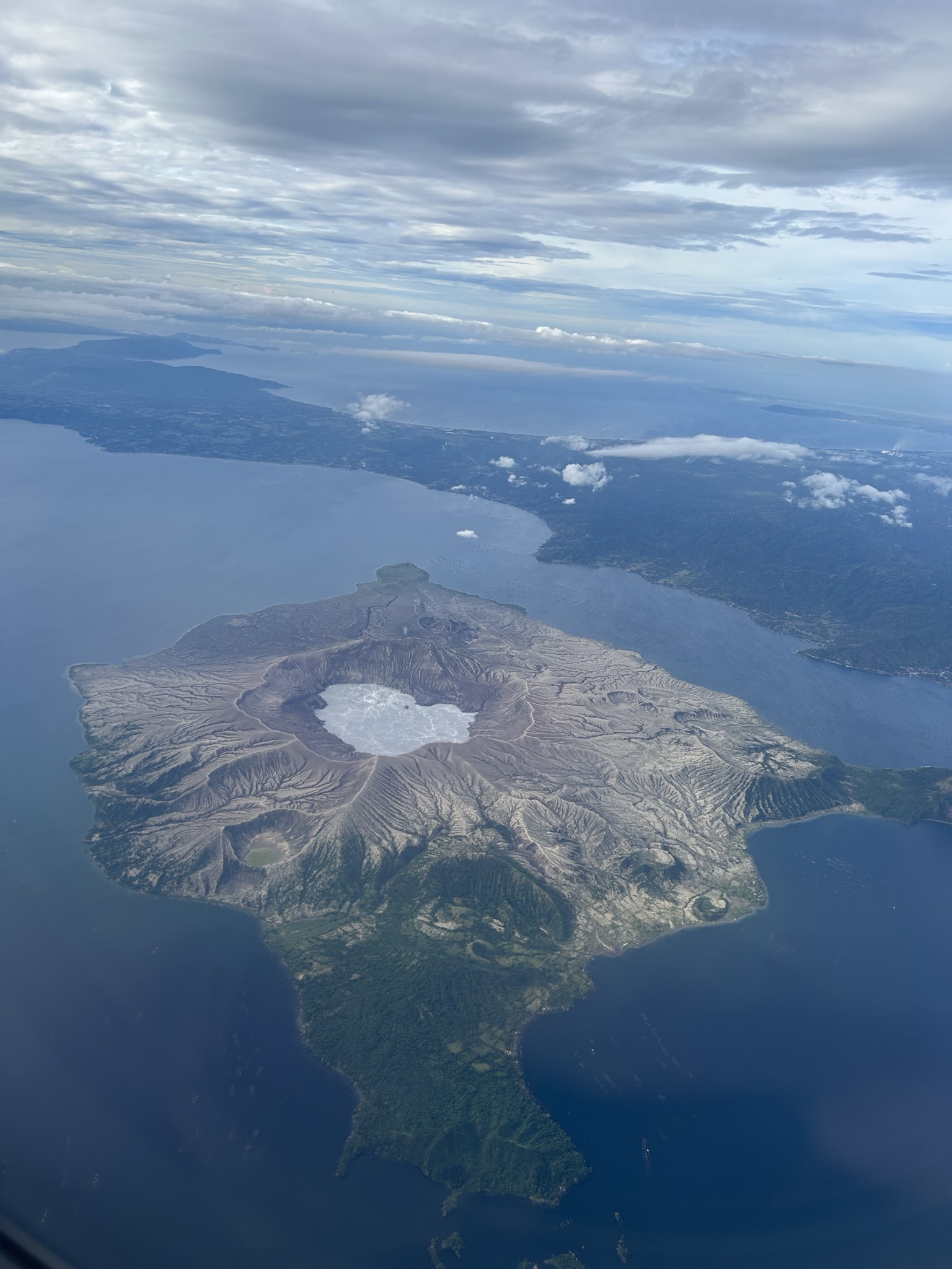 Picture of the taal volcano through the window in an airplane.